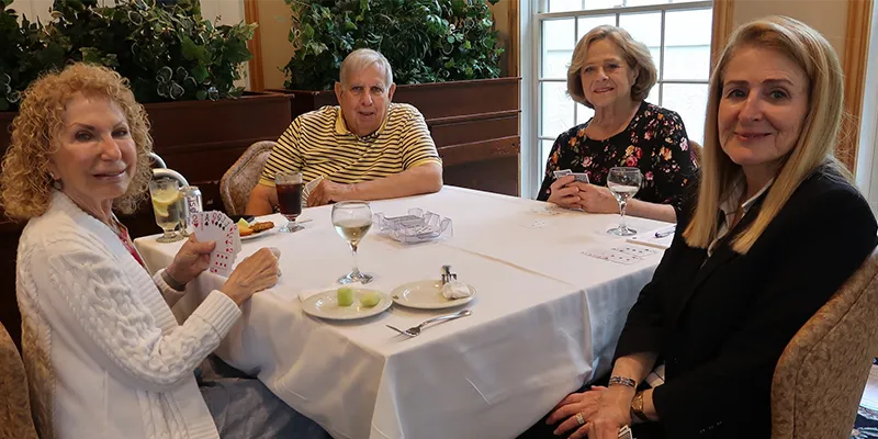 people posing while playing cards at a table